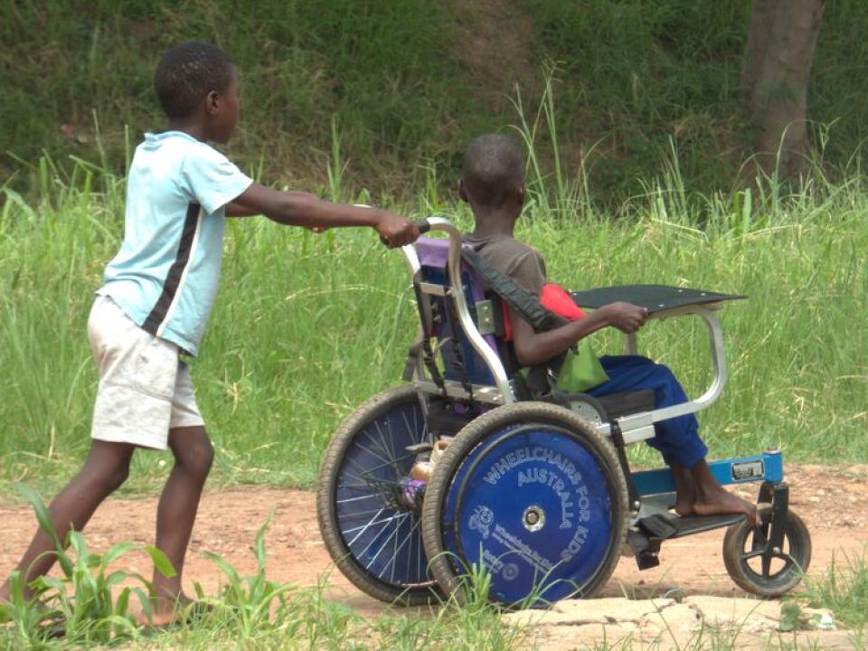 R92073 N No Restrictions Child Pushing Friend In Wheelchair By Peter Chifundu